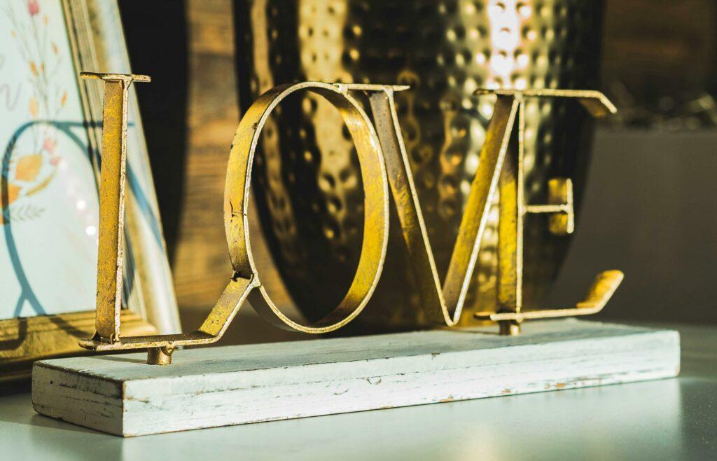 Valentinstag Dinner zu Hause 1 Ein goldener LOVE-Schriftzug macht sich gut auf einem Sideboard. Vor allem bei einem Valentinstag Dinner zu Hause.