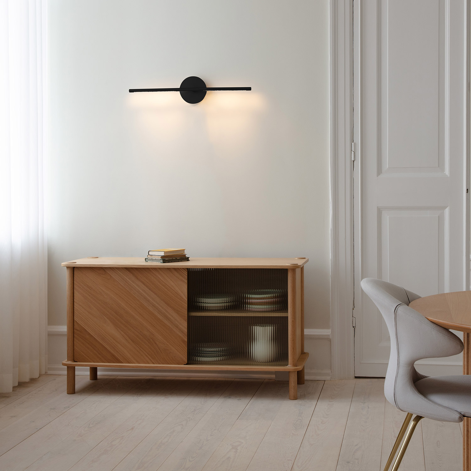 UMAGE Omni Wandlampe schwarz ueber sideboard 106517